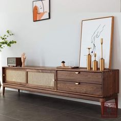 a large wooden cabinet sitting on top of a tiled floor next to a vase with flowers