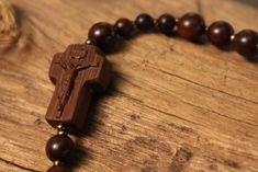 +.This is a rosary bracelet made of wood. The crucifix and the beads are constructed of wood. +.The wooden rosary is beneficial because you can feel the softness of the wood while praying. The more you contact wood, the more it takes on a natural brilliance. +.Surinamese ebony was used to make the crucifix. The light brown tone of Surinamese ebony is appealing. Surinamese ebony is so hard that it may be carved finely. It is carved over a long period of time rather than molded for a few minutes. Handmade Brown Rosary Bracelet As Gift, Spiritual Brown Rosary Bracelet For Gift, Gift Rosary Bracelet With 8mm Beads And Crucifix, Spiritual Rosary Bracelet With Cross Shape, Spiritual Cross Rosary Bracelet For Gift, Spiritual Cross Rosary Bracelet Gift, Spiritual Gift Rosary Bracelet With Cross, Jujube Tree, Wooden Rosary