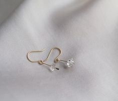 These dainty earrings are a cute way to add a little subtle sparkle to your look! Elegant and understated crystal earrings, but with a raw feel to them. The clean design of these earrings makes them really classy and versatile. Each earring contains a teeny floating Herkimer diamond. Herkimer diamonds are mined from a specific mine from New York State and are known by the double termination (pointy on both sides of the crystal) They are held in a little drop of brass, hammered for a rough textur Delicate Crystal Drop Earrings, Dainty Hypoallergenic Crystal Earrings For Everyday, Minimalist Crystal Earrings For Everyday, Minimalist Dangle Crystal Earrings With Ear Wire, Minimalist Crystal Drop Earrings With Ear Wire, Minimalist Sterling Silver Crystal Earrings For Everyday, Minimalist Dangle Crystal Earrings, Minimalist Crystal Drop Earrings, Everyday Minimalist Sterling Silver Crystal Earrings