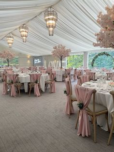 the inside of a tent with tables and chairs set up for a formal function in pink