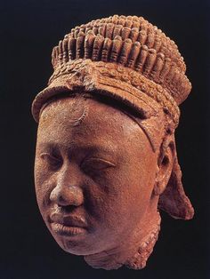 an old clay head with a hat on it's head and eyes closed to the side