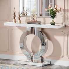 a table with a mirror and vase on it in front of a pink wallpapered room