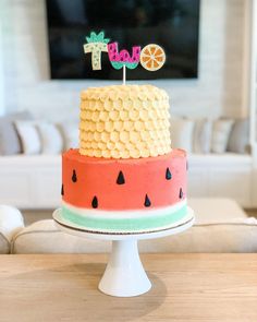 a watermelon cake with the word baby spelled out on top is sitting on a table in front of a television