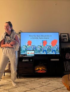 a woman standing in front of a flat screen tv