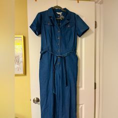 Brand New, Tags And Extra Button Still Attached. Blue Jean Jumpsuit With Button Up Front And Waist Tie Belt (5 Belt Loops To Hold Securely). Short Sleeves And 6 Pockets, Two On Front Hip, Two On Front Breast, Two (Still Sewn Shut) On Butt. Wide Leg Relaxed Fit. Summer Workwear Denim Jumpsuit With Button Closure, Summer Denim Jumpsuit For Work With Button Closure, Collared Denim Jumpsuit With Button Closure, Workwear Summer Denim Jumpsuit With Buttoned Pockets, Summer Denim Jumpsuit With Buttons For Work, Blue Denim Workwear Jumpsuit With Short Sleeves, Collared Blue Jumpsuits And Rompers For Spring, Blue Collared Jumpsuits And Rompers For Spring, Blue Short Sleeve Denim Jumpsuit For Work