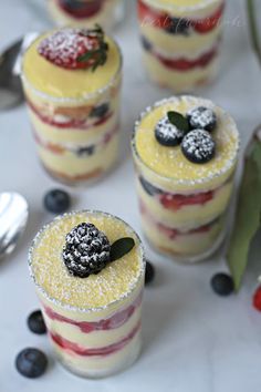 small desserts with berries and powdered sugar on the top are arranged in rows