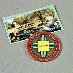 two badges on the back of a car with an image of cars in the background