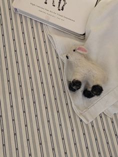 a stuffed animal laying on top of a bed next to a book