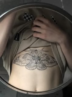 a close up of a person with a butterfly tattoo on their stomach