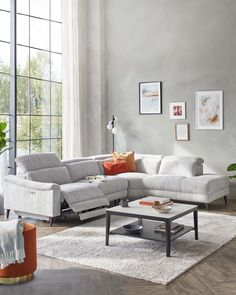 a living room with a sectional couch and coffee table in front of a large window