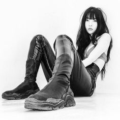 a black and white photo of a woman sitting on the floor with her legs crossed