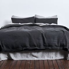 a bed with black linens and white pillows