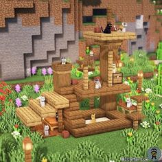 an image of a cat house in the middle of some flowers and grass with cats sitting on it