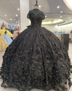 Make a bold and unforgettable statement with the Black Ball Gown Off the Shoulder Quinceanera Dress. This dress is crafted from luxurious tulle fabric and is adorned with intricate appliqued details that add texture and depth. A stunning bow knot at the back gives the dress a playful yet elegant finish, perfect for making a statement at your quinceanera. The off-the-shoulder neckline exudes sophistication, beautifully framing your shoulders and decolletage. The chapel train adds a touch of grand Black Gown For Quinceanera, Elegant Black Dress For Quinceanera, Black Floor-length Dress For Quinceanera, Elegant Black Ball Gown For Quinceanera, Black Fitted Bodice Ball Gown For Quinceanera, Black Floor-length Ball Gown For Quinceanera, Black Floor-length Gown For Quinceanera, Black Quinceanera Dress With Fitted Bodice, Black Dress With Fitted Bodice For Quinceanera