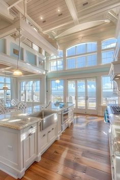 a large kitchen with an island in the middle and lots of windows on both sides