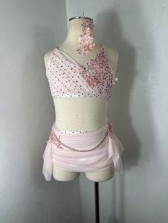 a mannequin wearing a pink and white dress with sequins on it