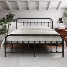 a bed with metal frame and headboard in a room next to a plant on the floor