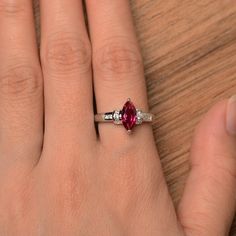 It is a lab ruby ring. The main stone is 5mm*10mm marquise cut, weight about 1.18 carats. The basic metal is sterling silver and plated with rhodium. To change the metal to a solid gold (white/rose) or platinum is also available, please ask for a quotation if you want. You can also go to my shop Home for more elegant rings: https://www.etsy.com/shop/godjewelry?ref=hdr_shop_menu More ruby rings: https://www.etsy.com/shop/godjewelry?section_id=20709238 Customization is always welcome and please fe Silver Marquise Ruby Ring For Anniversary, Marquise Ruby Promise Ring With Prong Setting, Red Marquise Cut Birthstone Ring Gift, Ruby Jewelry With Marquise Cut For Gifts, Silver Marquise Cut Ruby Promise Ring, Gift Ruby Ring With Marquise Cut Birthstone, Marquise Ruby Ring With Accent Stones For Promise, Elegant Red Marquise Cut Birthstone Ring, Gift Marquise Cut Ruby Ring Fine Jewelry