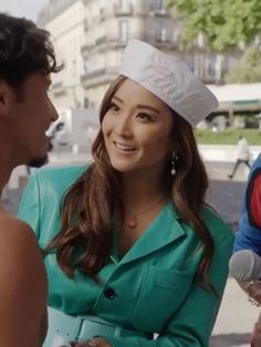 a man and woman talking to each other in front of a microphone on the street