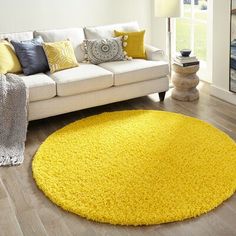 a living room with a white couch and yellow rug