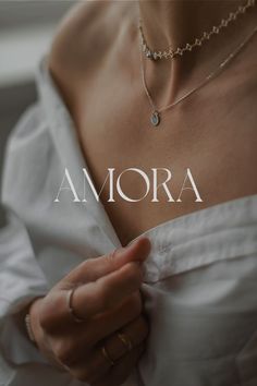 a woman wearing a white dress and holding onto her shirt with the word amora on it