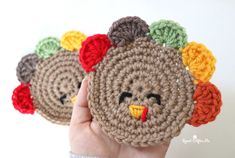 two crocheted turkey coasters with faces on them