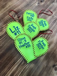 four neon green softballs with the number 12 on them are sitting on a wooden table