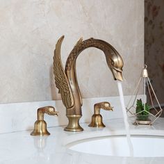 a golden faucet with water running from it's head in a bathroom