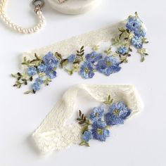 This beautiful stretch lace Wedding garter set is made with blue embroidered flowers, green leaves and stretch lace. Custom sized just for you and comes in a gift box.  Choose your lace color (secondary color) and small flower color (primary color). Any color combination will still have the larger blue flowers and green leaves. MEASURING INSTRUCTIONS: Use a soft tape measure or string and ruler. Measure where you want to wear your keepsake (the larger) garter. Measure a bit snug, not too tight or too loose. Order your actual measurement and I will take some off so it stretches to fit. The toss garter will be made smaller than the keepsake. SHIPPING: Each item is custom handmade to order and will ship out 3-5 business days after you order. Then shipping takes another 2-5 days. Most orders i Blue Garter Belt, Lace Wedding Garter Set, French Country Wedding, Wedding Garter Blue, Wedding Garter Lace, Blue Garter, Wedding Garter Set, Lace Bride, Wedding Garters