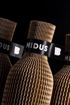 three brown vases with black and white labels on them, sitting side by side