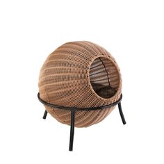 a wicker ball chair with black legs and a cat bed on top of it