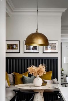 a living room with a couch, table and pictures hanging on the wall above it