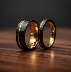 two wedding rings sitting on top of a wooden table