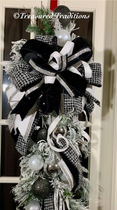 a black and white christmas wreath hanging on the front door