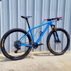 a blue mountain bike parked in front of a building