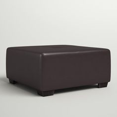 a brown ottoman sitting on top of a white floor