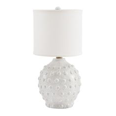 a white table lamp with a white shade on it