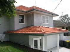 a house with a red tiled roof and white trim