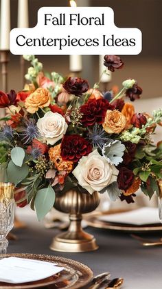 a centerpiece with flowers and greenery on a table