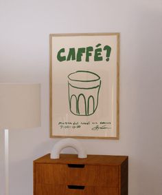 a wooden dresser sitting next to a lamp on top of a hard wood floor under a framed poster