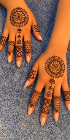 two hands with henna tattoos on them