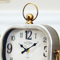 an old town clock is sitting on a table with two golden numbers and a key