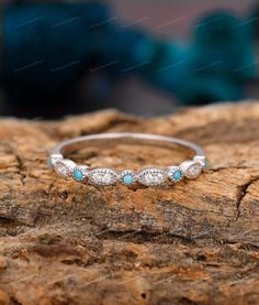 a white gold ring with diamonds and turquoise stones