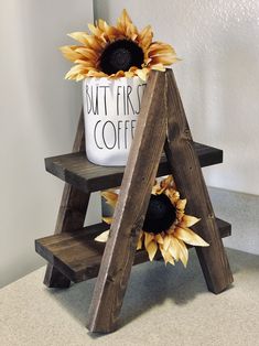 a sunflower sitting on top of a wooden step next to a coffee cup holder