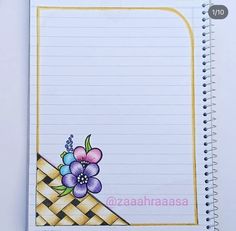 an open notebook with flowers and checkered paper on the cover, next to a pen