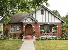 a small brick house with white trim and brown front door is shown in the foreground