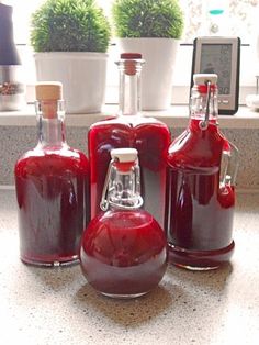 three red glass bottles sitting on top of a counter