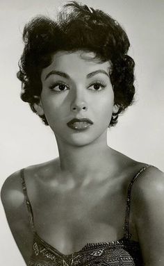 an old black and white photo of a woman with short hair wearing a bra top