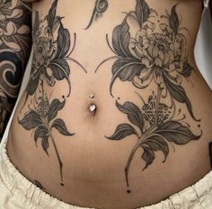 a woman's stomach with tattoos on it