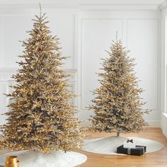 two christmas trees with gold tinsel on them